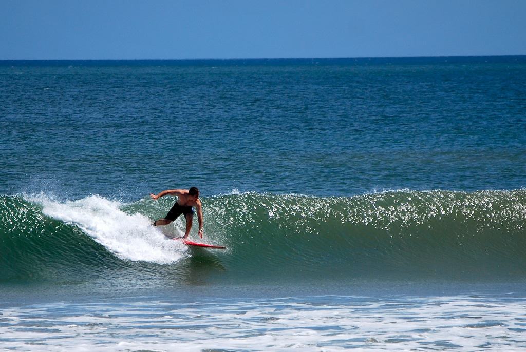 Persona que practica surf en la playa de Kuta en Bali